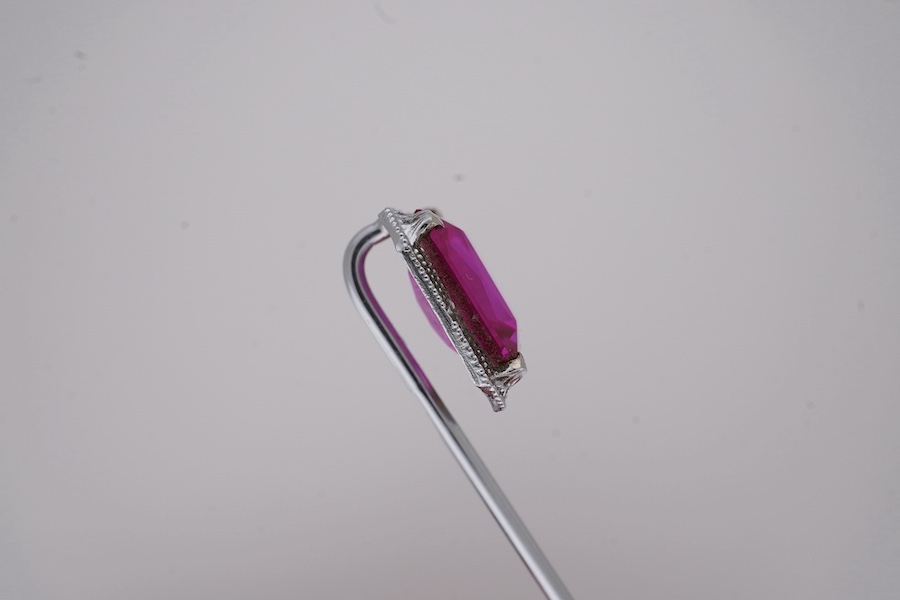 A North American? 10k white metal and single stone emerald cut synthetic ruby set stick pin, 55mm, gross weight 1.1 grams. Condition - fair to good